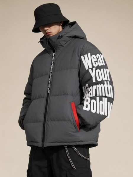 Urban Explorer In Midnight Puffer Urban explorer wears charcoal puffer jacket with bold white slogan 'wear your warmth boldly' on sleeve, paired with black bucket hat and cargo pants.