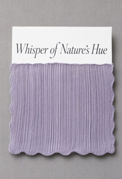 Soft Sage Mesh Fabric Swatch A soft lavender mesh fabric swatch with scalloped edges, labeled 'whisper of nature's hue', displayed against a neutral gray textured backdrop.