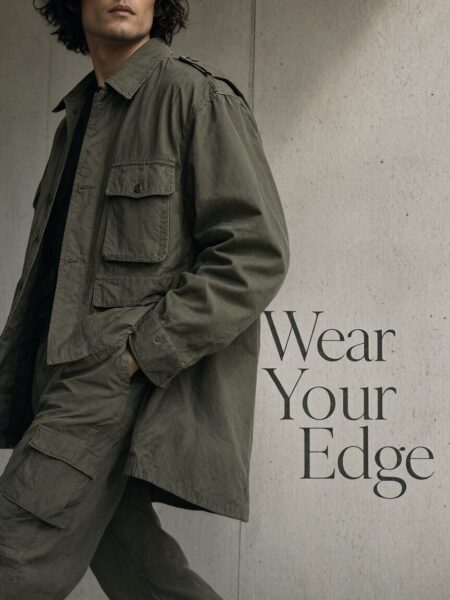 Rugged Gray Trench Jacket Display Man wearing olive green military-style trench coat and matching pants against textured concrete wall.