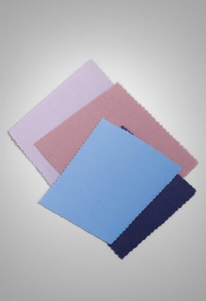 Soft Blue Fabric Swatches Over White Four soft fabric swatches in lavender, pink, light blue, and navy arranged diagonally against a gray backdrop.