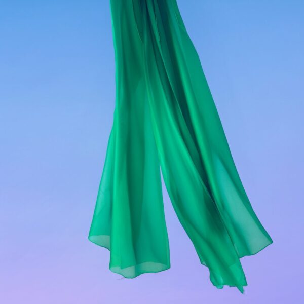 Ethereal Crimson Silk Drapes Ethereal green silk fabric flowing gracefully against a soft blue-to-purple gradient sky backdrop.