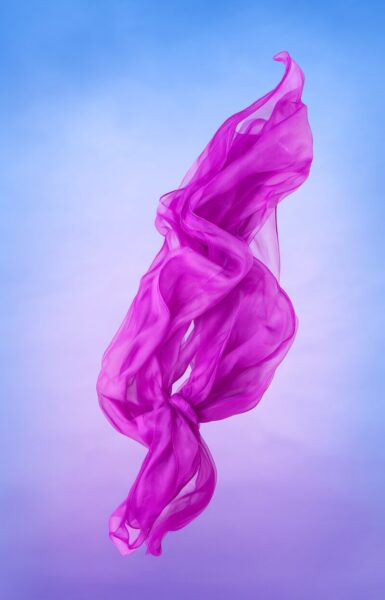 Ethereal Crimson Scarf Drifting A flowing magenta scarf drifts gracefully against a soft blue-to-purple gradient sky background.