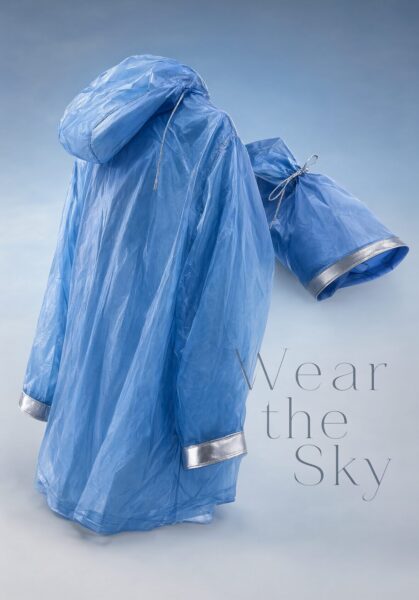 Transparent Blue Raincoat With Folded Sleeve A translucent blue raincoat with silver-trimmed cuffs and a folded sleeve rests against a soft gradient background.