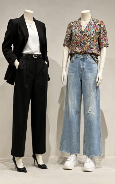 Two Mannequins Showcasing Contrasting Styles Two mannequins display contrasting styles: one in black blazer and trousers with heels, another in colorful blouse and ripped jeans with chunky sneakers.