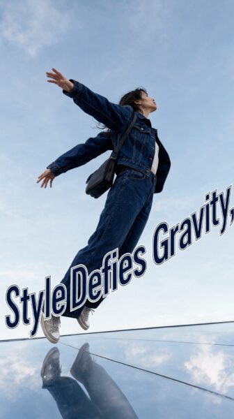 Floating Urban Explorer A woman in denim outfit leaps mid-air above reflective surface, arms outstretched against blue sky.